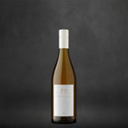 A single bottle of Harvey & Harriet White with a white label and a white capsule cap, centered against a dark textured gray background.