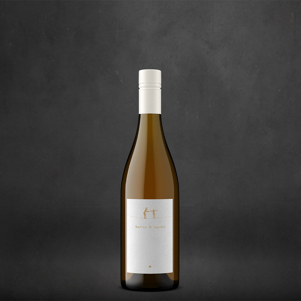A single bottle of Harvey & Harriet White with a white label and a white capsule cap, centered against a dark textured gray background.